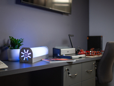 UV-C-Lmpe neben einem Schreibblock, Drucker und diversen anderen Gegenständen auf einem Schreibtisch