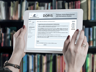 Bücherwand, davor ein Tablet, auf dem die Startseite des DORIS zu sehen ist