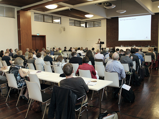 Eine Rednerin auf dem Podium referiert zum Thema Risikowahrnehmung in der Bevölkerung