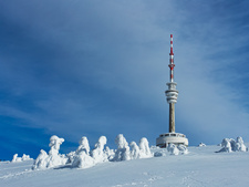Ein Funkturm steht in einer verschneiten Landschaft.
