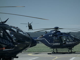 Zwei gelandete Hubschrauber und einer in der Luft. (Bild anzeigen)