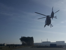 Hubschrauber in der Luft, Kraftwerksgelände im Hintergrund