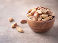 Bowl with Brazil nuts, some lying next to the bowl