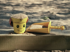 a sandbox in the shade with toy bucket and spade