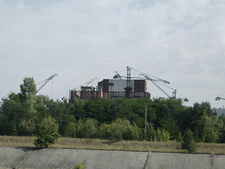 The ruins are surrounded by rusty building cranes