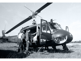 Two people are getting into a Bundeswehr helicopter